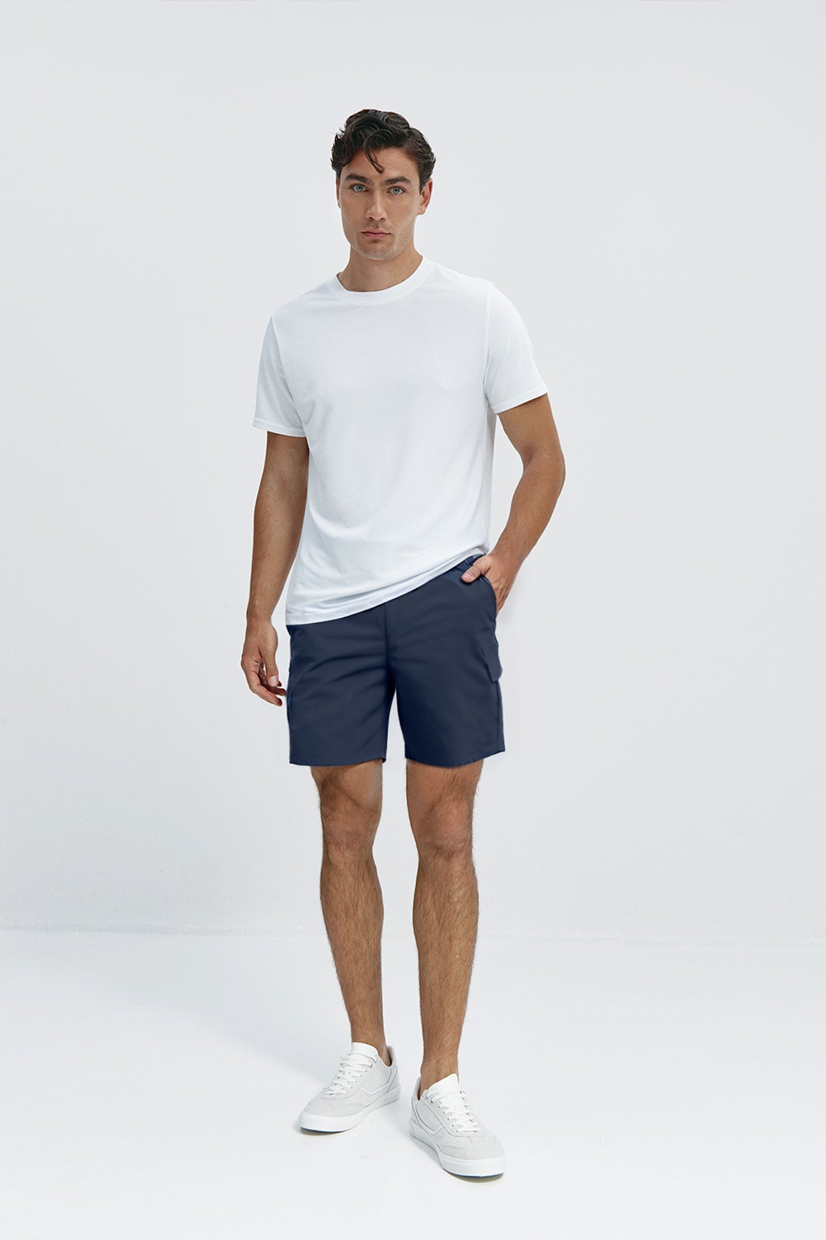 Bermudas cargo color azul marino, con múltiples bolsillos y tejido sin arrugas, flexibles y ligeras, perfectas para viajar y disfrutar del verano. Foto cuerpo entero